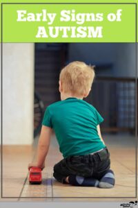 preschool boy playing with a toy car showing early signs of autism