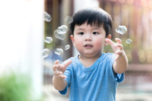 PANDAS-PANS-boy-playing-bubbles-language-delay